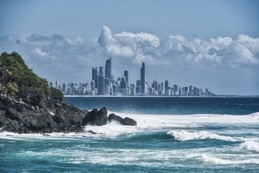 Image of a coastal cliff with a city and skyscrapers in the background