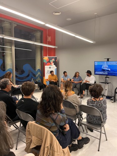 A group of people sitting in a room with a speaker