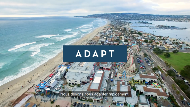 Aerial image of a coastal bay with buildings and box with the text "Adapt"