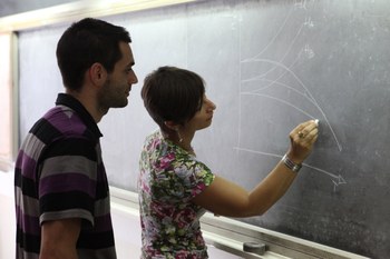 una studentessa e uno studente alla lavagna